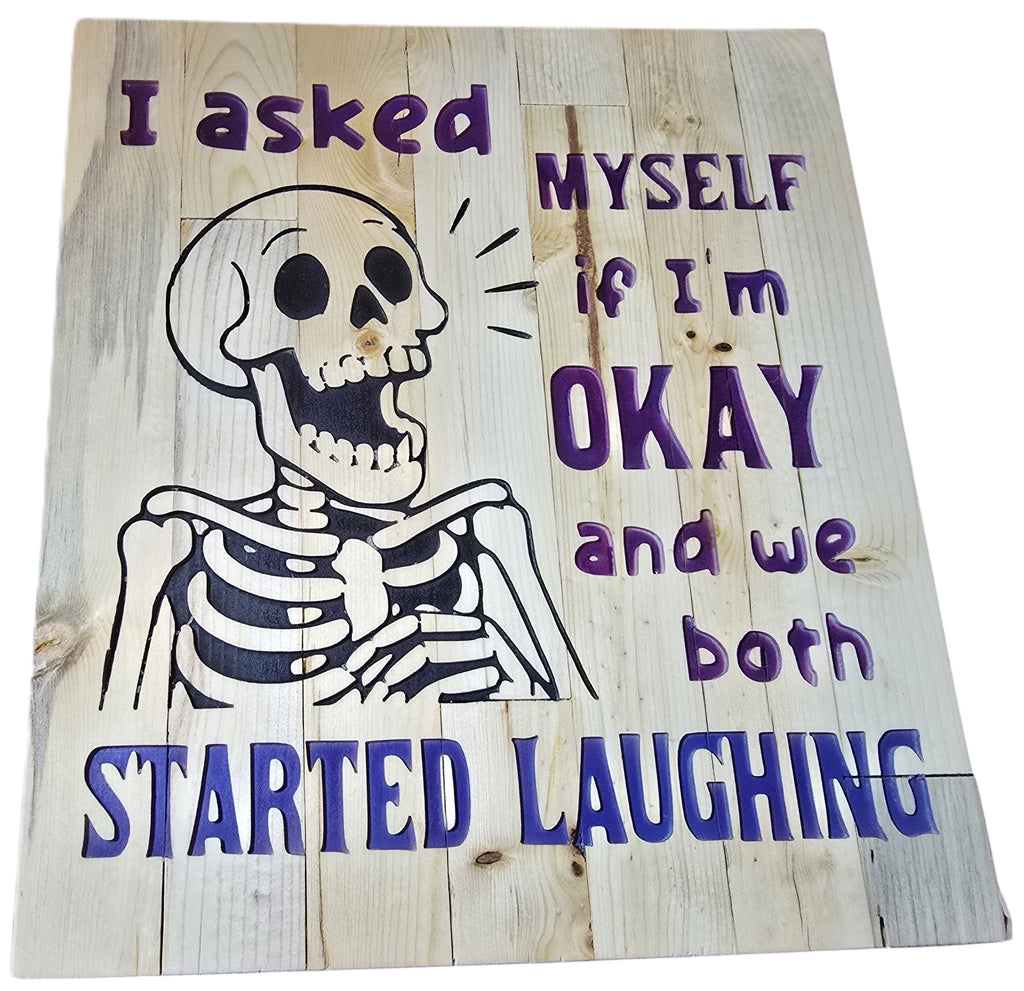 TK Wood Designs reclaimed wood sign with a skeleton graphic and purple text reading "I asked MYSELF if I'm OKAY and we both STARTED LAUGHING."