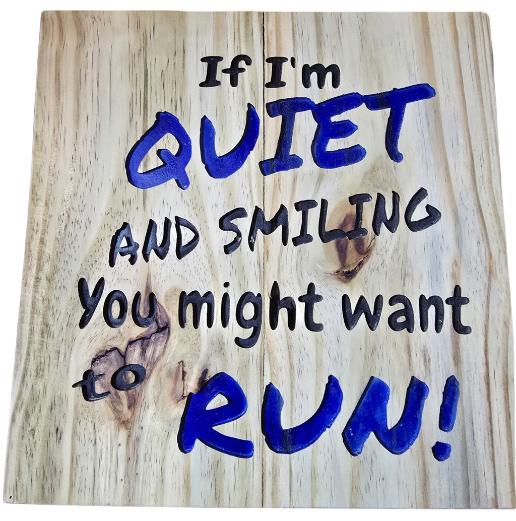 TK Wood Designs natural wood wall art with carved blue lettering saying "If I'm Quiet and Smiling, You Might Want to Run!"