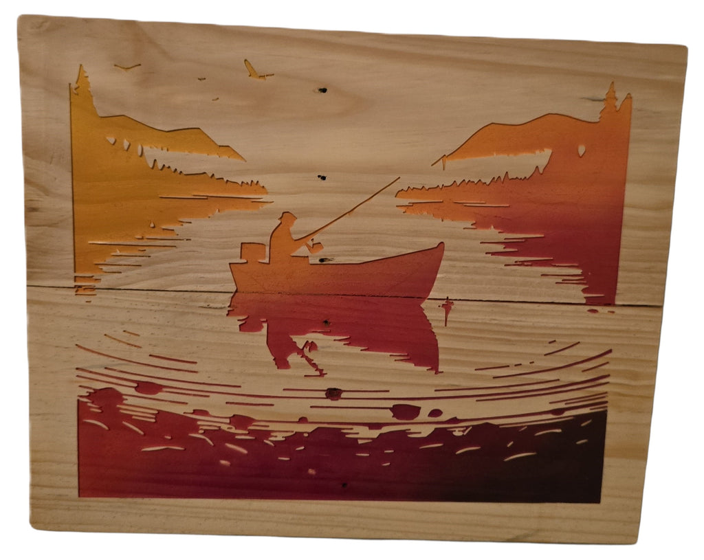 TK Wood Designs wooden wall art of a fishing scene with a lone angler in a boat at sunset, featuring layered wood and gradient colors.