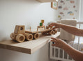 TK Wood Designs natural wood flatbed semi-truck toy with wooden wheels and cargo stakes.